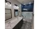 Bathroom with modern vanity, dual sinks, decorative tile flooring, and a shower with a blue tiled wall at 1352 W Spine Tree Ave, Queen Creek, AZ 85140