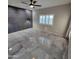 Spacious bedroom with modern accent wall, tiled floors, and a bright window at 1352 W Spine Tree Ave, Queen Creek, AZ 85140