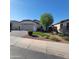 Charming home featuring well-manicured landscaping, green turf, and a spacious two-car garage at 1352 W Spine Tree Ave, Queen Creek, AZ 85140