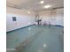 Spacious garage with epoxy flooring, storage shelves, and a water heater at 1352 W Spine Tree Ave, Queen Creek, AZ 85140