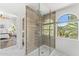 Bright bathroom featuring a walk-in shower with wood look tile, arched window, and marble floors at 13626 N 89Th St, Scottsdale, AZ 85260