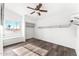 Bright bedroom featuring wood-look floors, a ceiling fan, and a window seat with natural light and closet space at 13626 N 89Th St, Scottsdale, AZ 85260