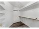 Walk-in closet with wood-look vinyl floors, shelves and rods, and white painted walls at 13626 N 89Th St, Scottsdale, AZ 85260