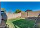 A grassy backyard is surrounded by a brick fence and small, raised garden bed at 1409 E Apollo Rd, Phoenix, AZ 85042