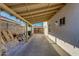A covered patio alongside a house with a concrete slab and trash cans at 1409 E Apollo Rd, Phoenix, AZ 85042