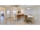 Bright dining area with bar seating, a white table with floral chairs, and modern gray-toned tile floors at 1409 E Apollo Rd, Phoenix, AZ 85042