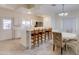 Dining area featuring tile floors, a dining table, and an attached kitchen with bar seating and white cabinetry at 1409 E Apollo Rd, Phoenix, AZ 85042