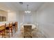 Bright dining area featuring a white table set, bar seating, tile floors, and seamless kitchen access at 1409 E Apollo Rd, Phoenix, AZ 85042