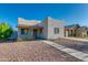 Exterior showcasing a one-story home with a stucco facade, gravel yard, and sidewalk leading to the front door at 1409 E Apollo Rd, Phoenix, AZ 85042