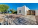 View of a quaint single-story home featuring a gravel yard and a covered parking area on a sunny day at 1409 E Apollo Rd, Phoenix, AZ 85042