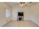 Bright living room with tile floors, ceiling fan, a decorative fireplace, and a large window with blinds at 1409 E Apollo Rd, Phoenix, AZ 85042