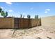 View of a backyard featuring a simple wooden gate and sand at 15410 N 60Th Ave, Glendale, AZ 85306