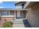 Close-up front porch with white door and stone siding and low maintenance front yard at 15410 N 60Th Ave, Glendale, AZ 85306