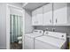 Functional laundry area with white cabinets and modern washer and dryer at 15410 N 60Th Ave, Glendale, AZ 85306