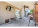 Covered patio area with ceiling fan and television, offering a relaxed outdoor living space at 15410 N 60Th Ave, Glendale, AZ 85306