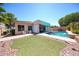 Exterior shot of the backyard with a pool, artificial turf, and a lounge area, perfect for outdoor enjoyment at 16368 W Cortez St, Surprise, AZ 85388