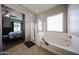 Large bathtub and glass enclosed shower in a bright bathroom, adjacent to the main bedroom at 16368 W Cortez St, Surprise, AZ 85388