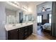 Beautiful bathroom with dual sinks, a dark vanity, and view into the spacious main bedroom at 16368 W Cortez St, Surprise, AZ 85388