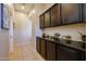 Elegant hallway with tiled floors and dark wood cabinets with decoratively adorned countertop at 16368 W Cortez St, Surprise, AZ 85388