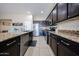 Stylish kitchen showcasing granite countertops, dark cabinetry and stainless steel appliances at 16368 W Cortez St, Surprise, AZ 85388
