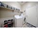 Functional laundry room includes a modern washer and dryer, shelving, and convenient shoe storage at 16368 W Cortez St, Surprise, AZ 85388