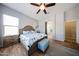 Comfortable main bedroom featuring wood-look floors, a cozy ottoman, and en-suite bathroom at 16368 W Cortez St, Surprise, AZ 85388