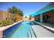 A serene backyard showcasing a sparkling pool with a water feature and an inviting covered seating area at 16368 W Cortez St, Surprise, AZ 85388