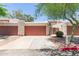 Exterior view of garage with red doors, desert landscaping, and neutral stucco at 1822 S River Dr, Tempe, AZ 85281