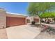 Street view of condo garages featuring stucco exteriors, desert landscaping and red doors at 1822 S River Dr, Tempe, AZ 85281
