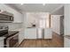 Bright kitchen features white cabinetry, stainless appliances, and an open concept layout with a view of the living area at 1822 S River Dr, Tempe, AZ 85281