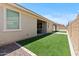 View of backyard artificial grass with covered patio, perfect for low-maintenance living at 18854 W Poinsettia Dr, Surprise, AZ 85388
