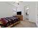 Bright bedroom with a ceiling fan, TV on wooden bureau, and en suite bathroom at 18854 W Poinsettia Dr, Surprise, AZ 85388