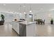 Open-concept kitchen with island seating, stainless steel appliances, and adjacent dining area at 18854 W Poinsettia Dr, Surprise, AZ 85388