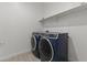 Contemporary laundry room features a modern washer/dryer set and shelf at 18854 W Poinsettia Dr, Surprise, AZ 85388