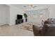 Stylish living room features a comfortable seating area, ceiling fan, and view of the windows at 18854 W Poinsettia Dr, Surprise, AZ 85388