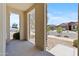 Inviting covered porch with stone-accented columns, providing a welcoming entrance to the home at 18854 W Poinsettia Dr, Surprise, AZ 85388