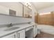 Double vanity bathroom with white cabinets, warm lighting, and tile accents at 19802 N 3Rd Ave, Phoenix, AZ 85027