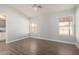 Bright bedroom with wood-look floors, ceiling fan, and natural light from two windows at 19802 N 3Rd Ave, Phoenix, AZ 85027