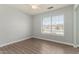 Light-filled bedroom with wood-look flooring and a large window overlooking the neighborhood at 19802 N 3Rd Ave, Phoenix, AZ 85027