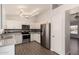 Spacious kitchen with stainless steel appliances, white cabinets, and modern lighting fixtures above wood-look flooring at 19802 N 3Rd Ave, Phoenix, AZ 85027