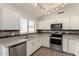 Updated kitchen boasts stainless steel appliances, white cabinetry, and a stylish backsplash complemented by wood-look flooring at 19802 N 3Rd Ave, Phoenix, AZ 85027