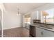 Bright kitchen with sliding door access, stainless steel dishwasher and modern cabinets over wood-look flooring at 19802 N 3Rd Ave, Phoenix, AZ 85027
