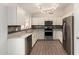 Well-lit kitchen featuring stainless steel appliances, light countertops, and stylish tile backsplash with wood-look flooring at 19802 N 3Rd Ave, Phoenix, AZ 85027