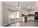 Bright kitchen with white cabinets, stainless steel appliances, and wood-look flooring with sliding door access to back yard at 19802 N 3Rd Ave, Phoenix, AZ 85027