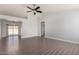 Open-concept living room with a sliding door, archway, ceiling fan and wood-look floors at 19802 N 3Rd Ave, Phoenix, AZ 85027