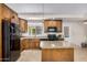 A kitchen with wood cabinets, granite countertops, black appliances, and a kitchen island at 2018 W Taro Ln, Phoenix, AZ 85027