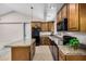 This kitchen has wood cabinets, granite countertops, an island, and stainless steel appliances at 2018 W Taro Ln, Phoenix, AZ 85027