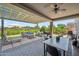 Outdoor patio with lounge area, dining table, grill, and a spacious covered seating area at 20198 E Rosa Rd, Queen Creek, AZ 85142