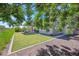 Lush backyard featuring a pergola-covered patio, artificial grass, and decorative rock at 20198 E Rosa Rd, Queen Creek, AZ 85142
