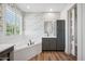 Well-lit bathroom featuring a soaking tub, stylish wallpaper, and wood floors at 20198 E Rosa Rd, Queen Creek, AZ 85142